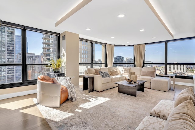 living area with recessed lighting, baseboards, a city view, and light wood finished floors