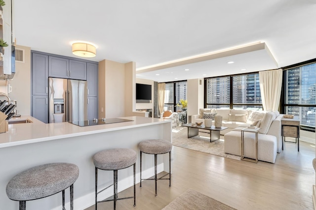 kitchen with open floor plan, light countertops, high end fridge, and gray cabinets