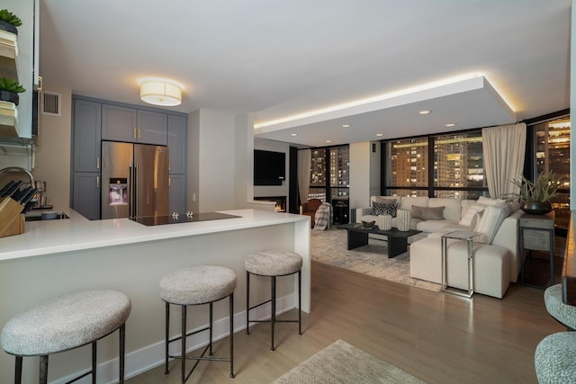 kitchen featuring gray cabinets, open floor plan, light countertops, and high quality fridge