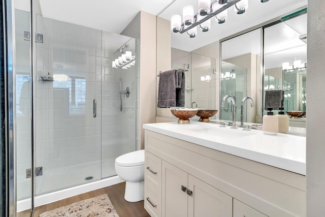 full bathroom featuring vanity, a stall shower, wood finished floors, and toilet