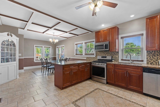 kitchen featuring stone counters, appliances with stainless steel finishes, sink, and kitchen peninsula