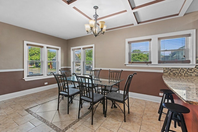 tiled dining room featuring coffered ceiling and a chandelier