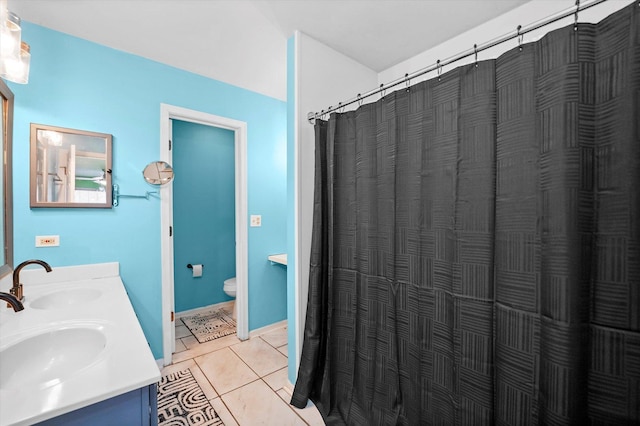 bathroom with a shower with curtain, vanity, tile patterned floors, and toilet