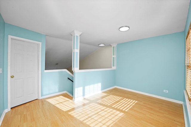 empty room with wood-type flooring and vaulted ceiling