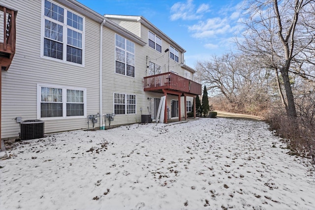 snow covered back of property featuring cooling unit