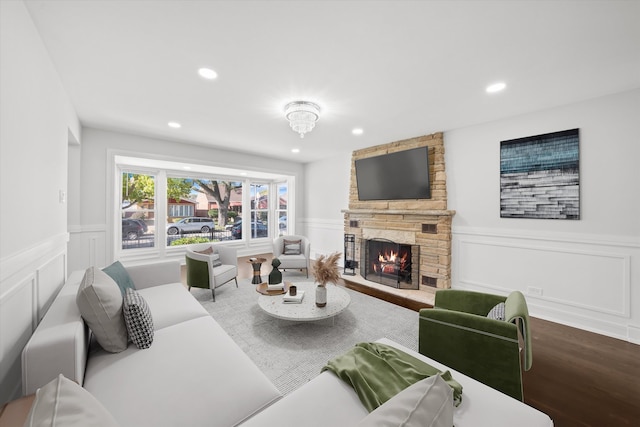 living room with hardwood / wood-style flooring and a stone fireplace