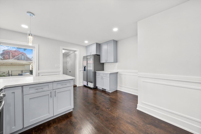 kitchen featuring gray cabinets, decorative backsplash, hanging light fixtures, stainless steel refrigerator with ice dispenser, and dark wood-type flooring