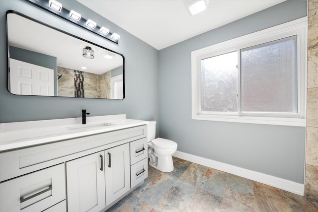 bathroom featuring vanity, toilet, and walk in shower