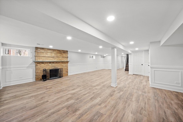 basement featuring a brick fireplace and hardwood / wood-style flooring