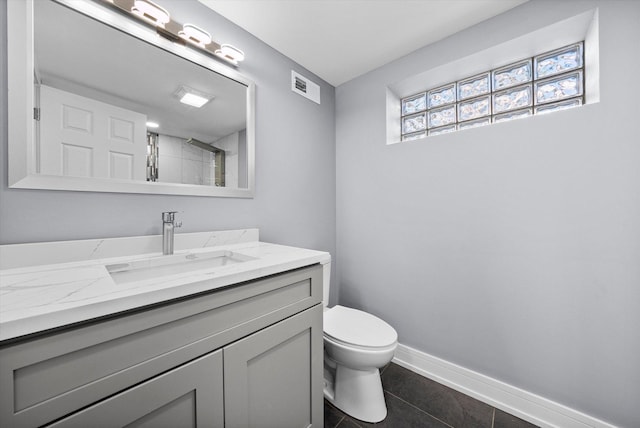 bathroom featuring vanity, toilet, and tile patterned flooring