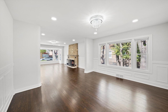 unfurnished living room with dark wood-type flooring and a fireplace