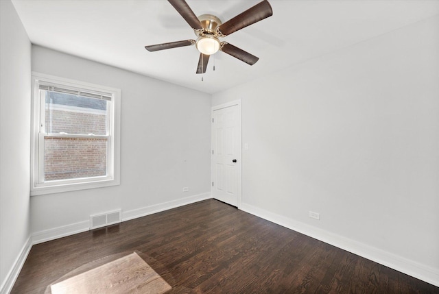 empty room with dark wood-type flooring and ceiling fan