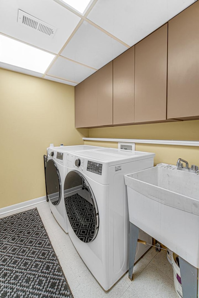 laundry area featuring independent washer and dryer, cabinets, and sink