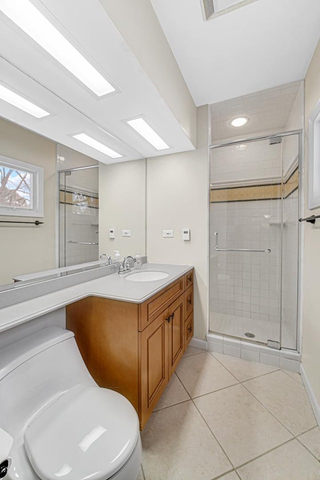 bathroom featuring tile patterned flooring, vanity, toilet, and walk in shower