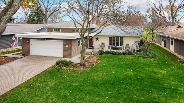 split level home featuring a garage, covered porch, and a front lawn