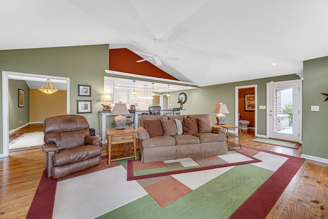 living room featuring vaulted ceiling, ceiling fan, and light wood-type flooring