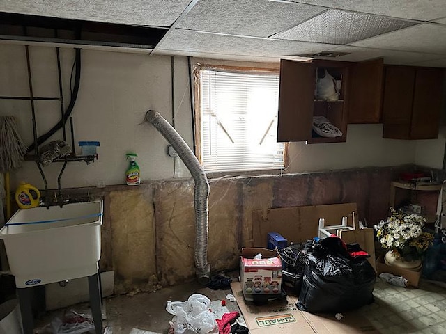 basement featuring sink and a drop ceiling