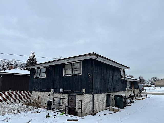 view of snow covered exterior featuring central AC unit