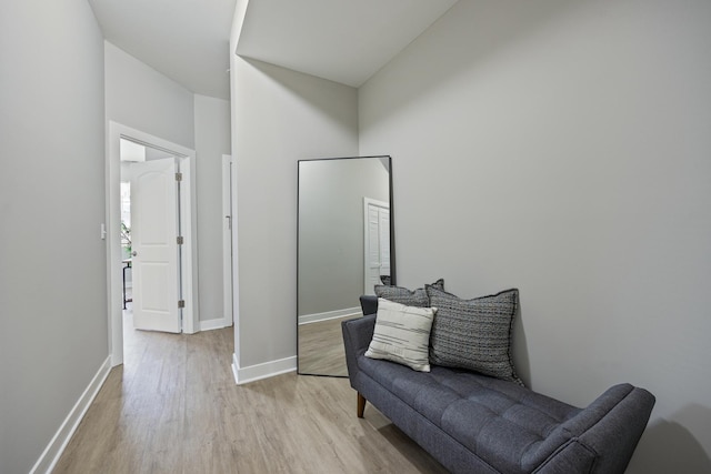 living area featuring a towering ceiling and light hardwood / wood-style floors