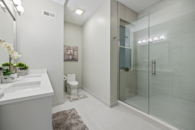 bathroom with tile patterned floors, vanity, toilet, and a shower with door