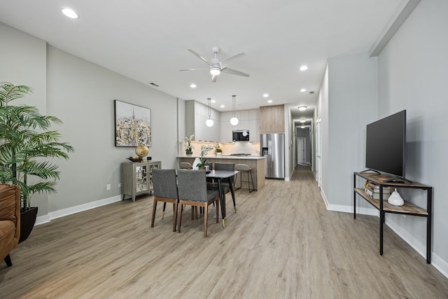 dining room with ceiling fan and light hardwood / wood-style flooring