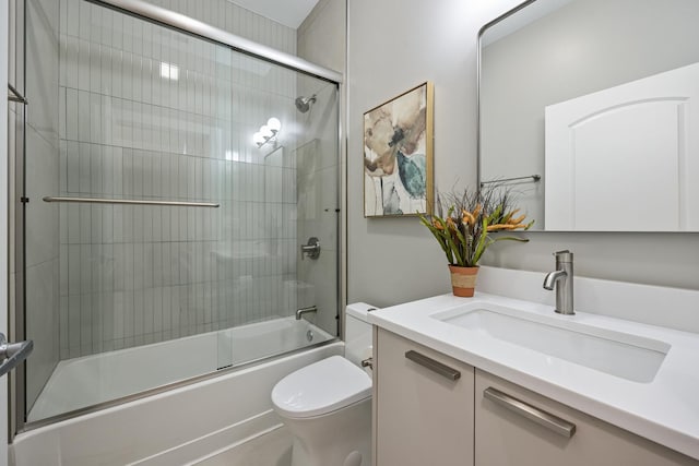 full bathroom featuring vanity, toilet, and combined bath / shower with glass door