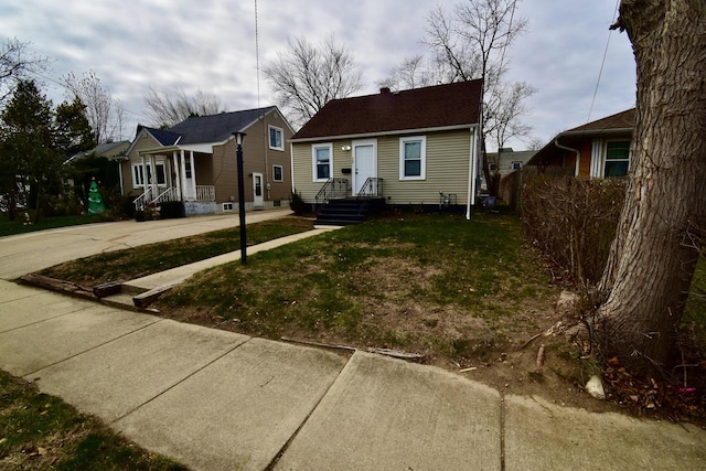 bungalow-style home with a front yard