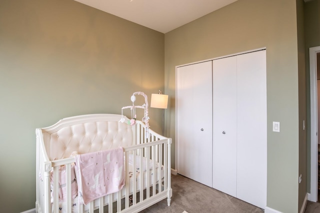 bedroom featuring a crib, a closet, and carpet flooring