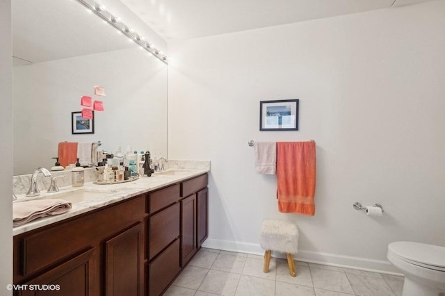 bathroom with tile patterned flooring, vanity, and toilet