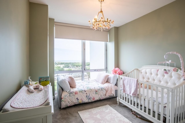 carpeted bedroom featuring an inviting chandelier