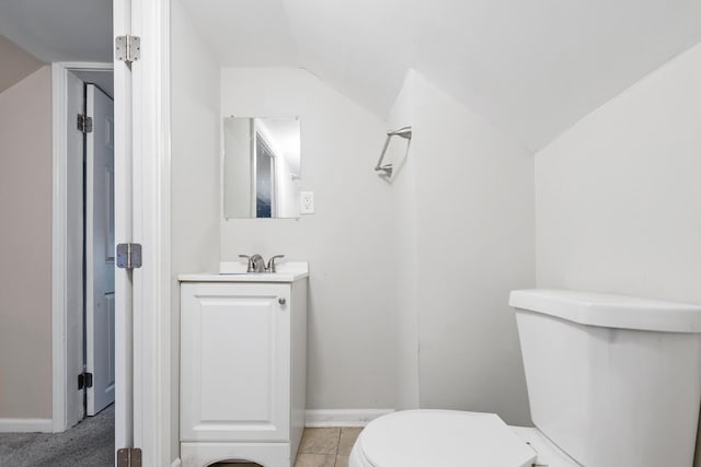 bathroom featuring vanity, lofted ceiling, and toilet