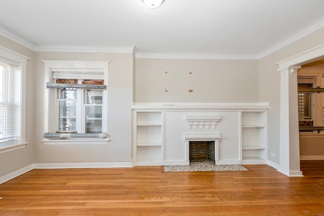 unfurnished living room featuring hardwood / wood-style floors, crown molding, built in shelves, and a brick fireplace