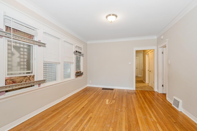 empty room with crown molding and light hardwood / wood-style flooring