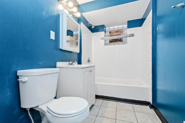 full bathroom featuring tile patterned flooring, vanity, tiled shower / bath, and toilet