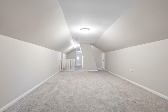 additional living space with lofted ceiling and light carpet