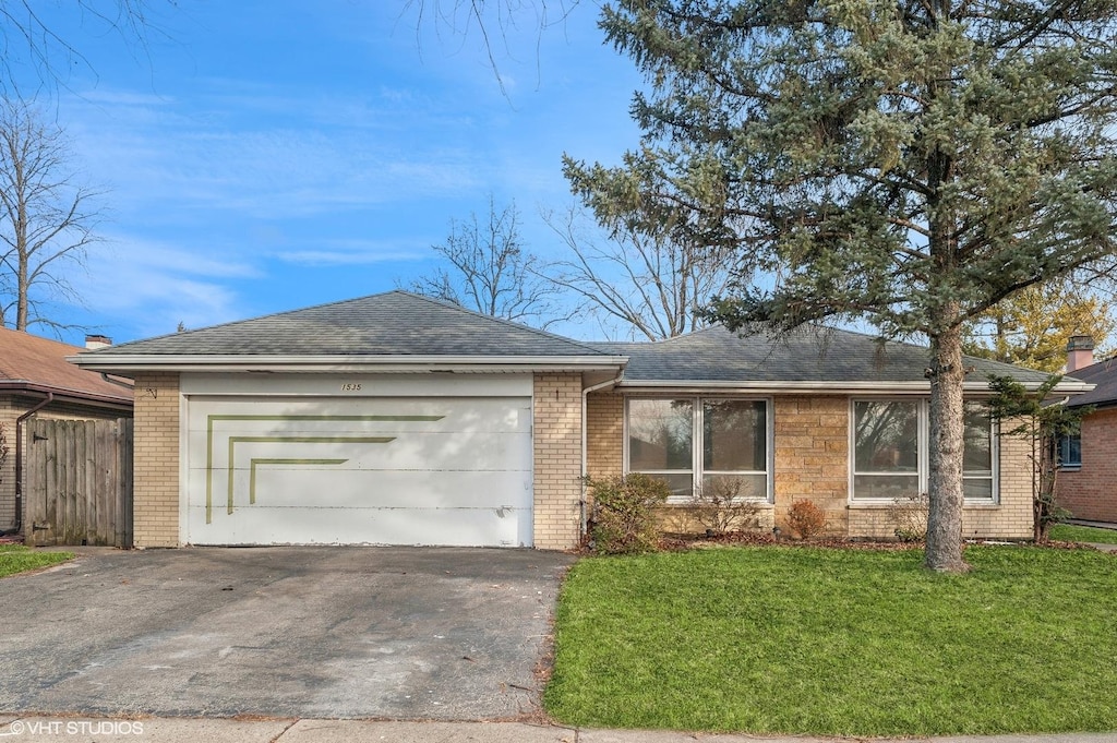 ranch-style house featuring a garage and a front lawn