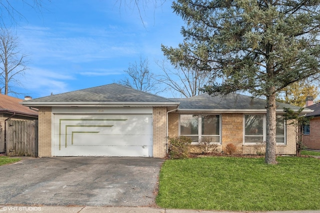 ranch-style house featuring a garage and a front lawn