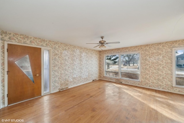 unfurnished living room featuring hardwood / wood-style flooring and ceiling fan