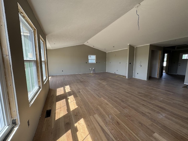 interior space featuring vaulted ceiling, visible vents, and wood finished floors