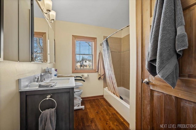 bathroom with shower / bathtub combination with curtain, toilet, vanity, wood finished floors, and baseboards