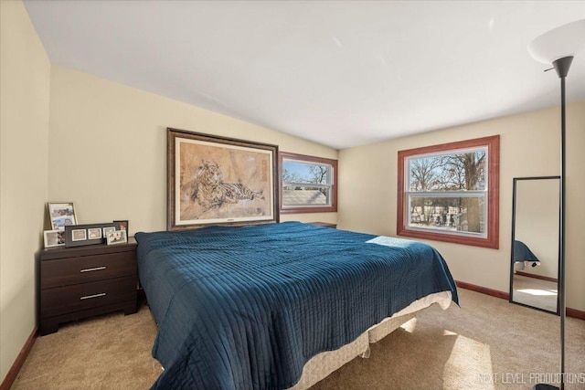 bedroom featuring light carpet, vaulted ceiling, and baseboards