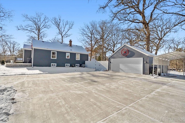 exterior space featuring a garage, a chimney, an outdoor structure, and fence