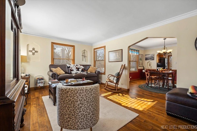 living area featuring a chandelier, arched walkways, crown molding, and hardwood / wood-style floors