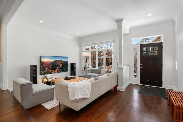 living room featuring dark wood-type flooring, ornate columns, and crown molding