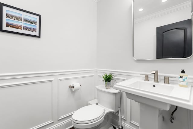 bathroom with crown molding, toilet, and sink