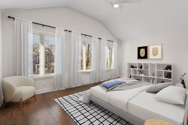 bedroom featuring dark wood-type flooring, vaulted ceiling, and ceiling fan