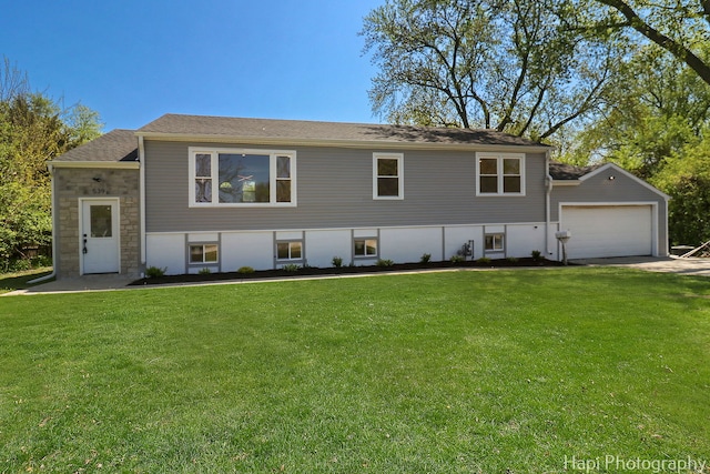 view of front of house featuring a front lawn, a garage, driveway, and stone siding