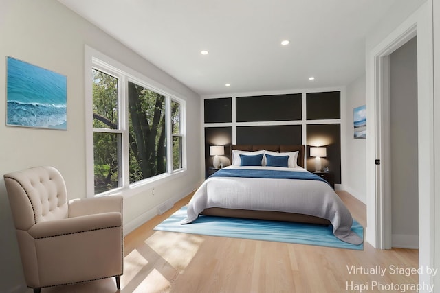 bedroom with baseboards, wood finished floors, and recessed lighting
