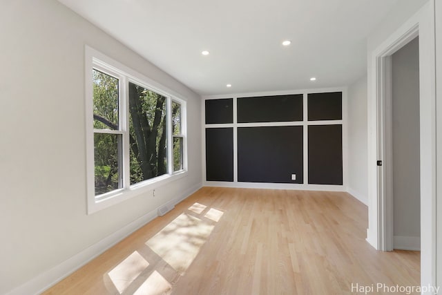 unfurnished room featuring recessed lighting, light wood-type flooring, and baseboards