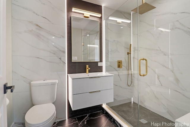 full bathroom with marble tiled flooring, a marble finish shower, vanity, toilet, and tile walls